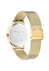 Goldfarbene Uhr mit einem Armband aus Edelstahl-Mesh, rundem Gehäuse und Glasboden, der mit geprägtem Branding und Wasserdichtigkeitslabel versehen ist.