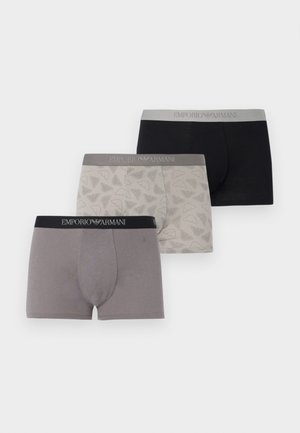 Tres bóxers para hombre de Emporio Armani en negro, beige con patrón de logo y gris sólido, cada uno con cintura de marca.