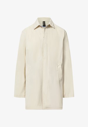 Béžová košile s dlouhým rukávem a zapínáním na knoflíky jako bunda s špičatým límcem a bočními kapsami, přední knoflíky zakryté légou.
