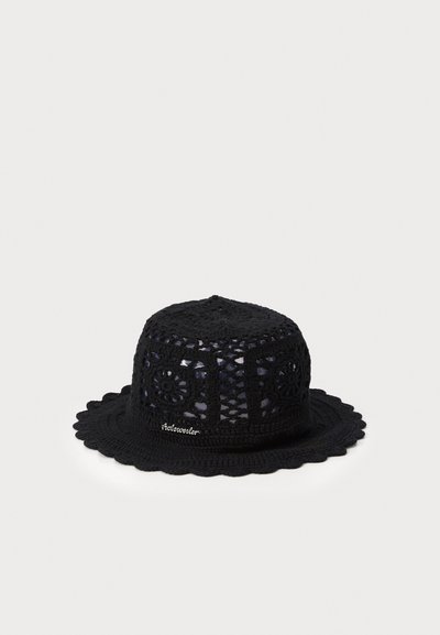 Chapeau noir en crochet avec un sommet rond, des découpes décoratives et un bord festonné. Présente des motifs floraux et une broderie subtile de la marque.