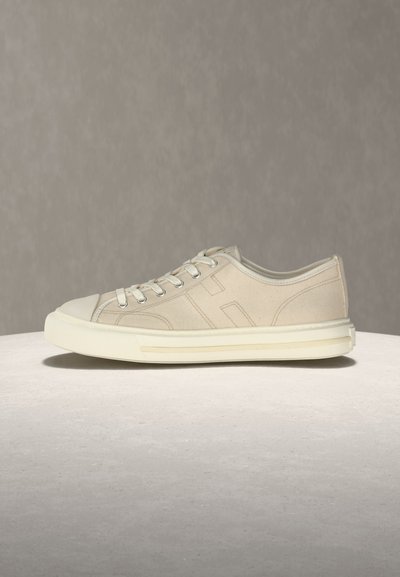 Μπεζ χαμηλά αθλητικά παπούτσια με παχιά λευκή σόλα, λευκά κορδόνια και διακριτική ραφή σε ουδέτερο φόντο.