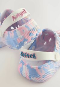 Värikäs puulokki, jossa on vaaleanpunainen ja sininen marmoroitu kuvio, valkoisilla säädettävillä hihnoilla, joihin on kohokuvioitu "Angel" ja "Stitch" pastelliväreillä.