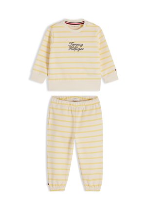 Langärmeliges Top mit cremegelben Streifen und passende Hose mit dem Schriftzug „Tommy Hilfiger“ auf der Brust sowie elastischem Bund und Bündchen.
