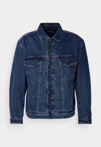 Mörkblå denimjacka med krage, två bröstfickor och knäppning med knappar. Har en något ostrukturerad passform och synlig sömnad.
