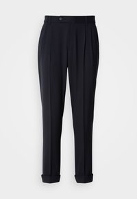 Navy tailored trousers with front pleats, a button closure, and rolled cuffs. Made of a smooth fabric with a structured fit.