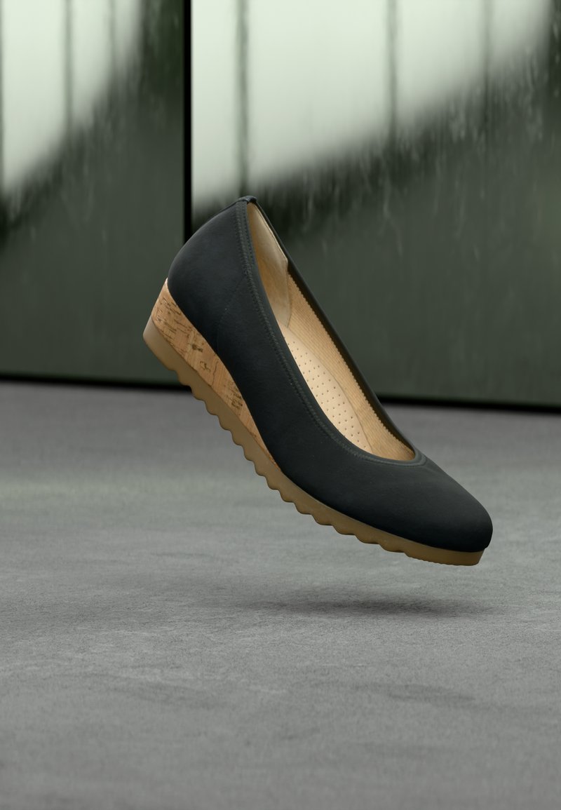 Μαύρο επίπεδο παπούτσι με στρογγυλεμένη μύτη, υφασμένη επάνω επιφάνεια και μεσόσολα με φελλό. Διαθέτει λαστιχένια σόλα με κυματιστό μοτίβο.