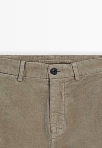 Chino in corduroy khaki con texture a righe verticali, dotati di chiusura con bottone nero e passanti per cintura. Design classico a taglio dritto.