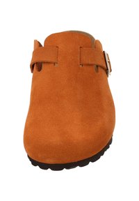 Oranje suède klompschoen met een ronde neus, zijbanden en een gestructureerde zwarte zool. Heeft accenten van zilverkleurig hardware op de banden.