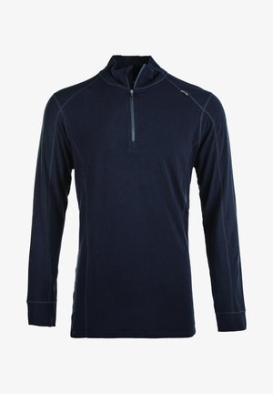 Zwart atletisch shirt met lange mouwen en halve rits, gecombineerd met olijfgroene tapered joggers met zijzakken en logo, gedragen met donkere sneakers.