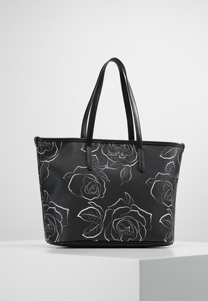 Musta nahkainen olkalaukku, jossa valkoiset ruusupiirrokset, kaksinkertaiset kahvat ja hillitty "Armani"-logo etuosassa, esillä valkoisella jalustalla.