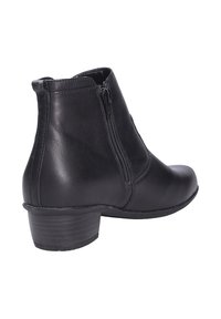 Stivaletto in pelle nera con zip laterale, punta tonda e tacco basso impilato. Texture liscia con dettagli di design minimalista.