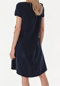 Marineblaue kurzärmlige Kleid mit geradem Schnitt, weichem Stoff und subtiler Textur. Verfügt über einen runden Ausschnitt und einen knielangen Saum.