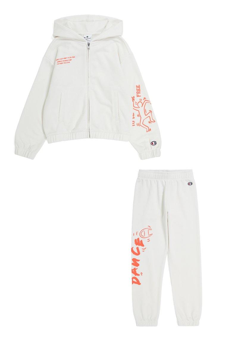 Felpa bianca con zip, decorata con testo e grafica arancione, abbinata a pantaloni jogger con un design simile. Realizzata in tessuto morbido ed elastico.