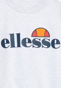 Lichtgrijze trui met een donkerblauw "ellesse"-logo en een kleurrijke halve cirkel in oranje en rood boven de tekst.