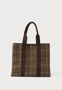 Καφέ τσάντα tote με καρό ύφασμα, δύο μακριές σκούρες καφέ λαβές και ένα μικρό στρογγυλό χρυσό έμβλημα στο κέντρο.