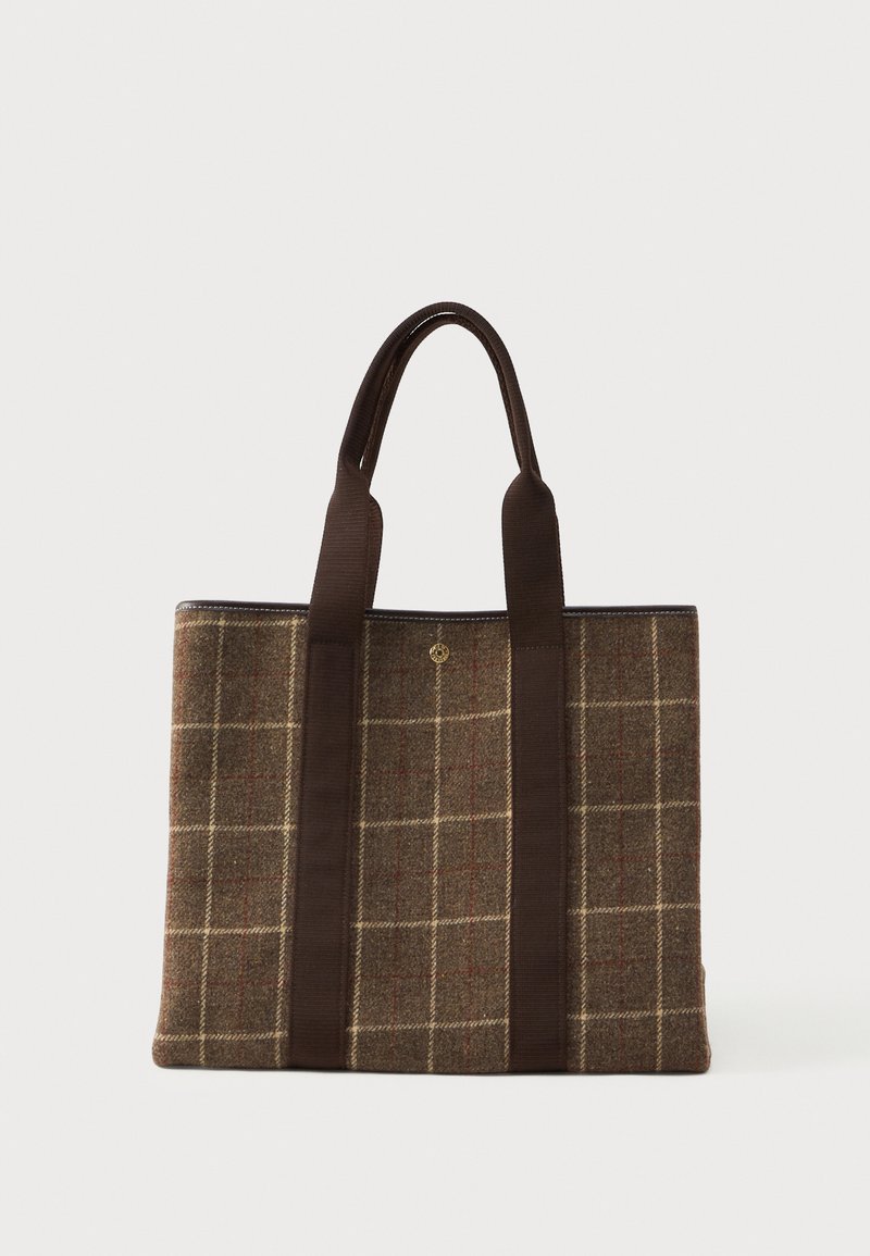 Καφέ τσάντα tote με καρό ύφασμα, δύο μακριές σκούρες καφέ λαβές και ένα μικρό στρογγυλό χρυσό έμβλημα στο κέντρο.