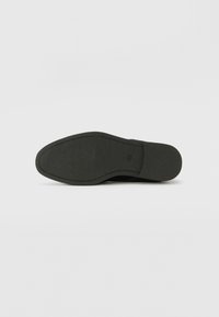 Svart skosåle med teksturert finish og glatte kanter. Gummimaterialet er solid, designet for grep og holdbarhet.