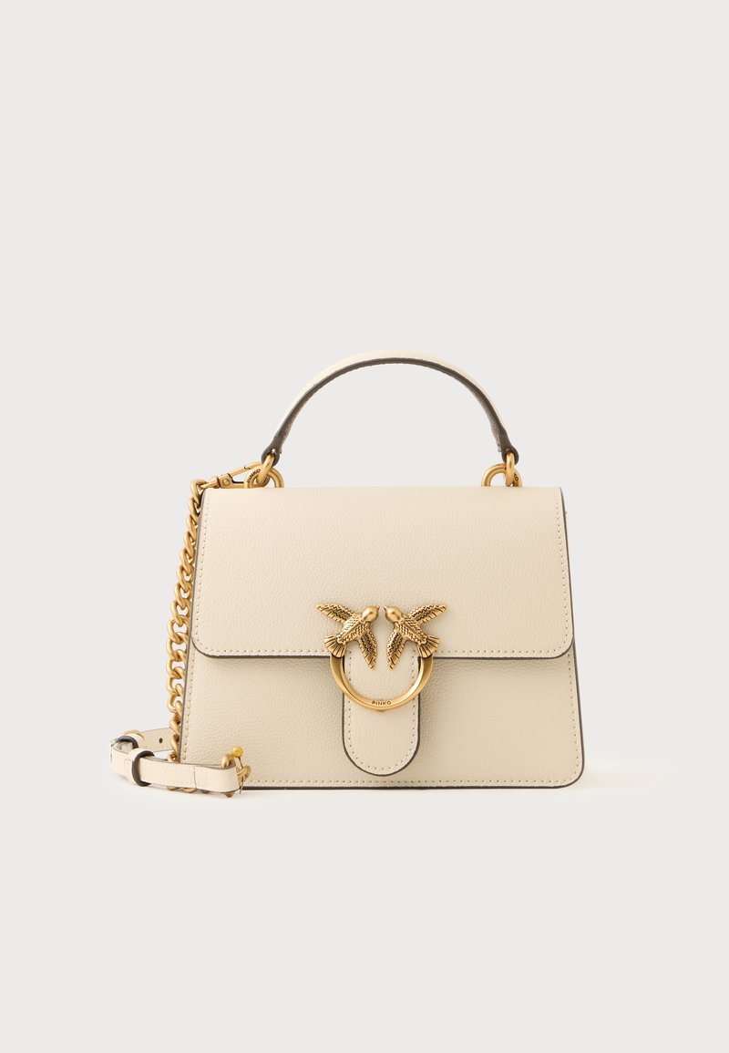 Borsa a mano in pelle color crema con manico superiore, tracolla a catena dorata e dettaglio fibbia a forma di uccello dorata sulla patta frontale.