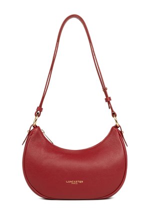 Sac à bandoulière en cuir rouge avec une forme arrondie, affichant une texture lisse, des accessoires en or et une bandoulière ajustable. Logo embossé à l'avant.