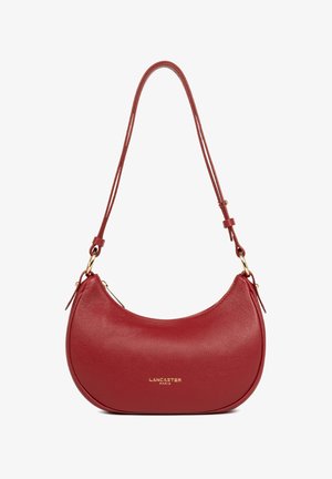 Sac à bandoulière en cuir rouge avec une forme arrondie, affichant une texture lisse, des accessoires en or et une bandoulière ajustable. Logo embossé à l'avant.