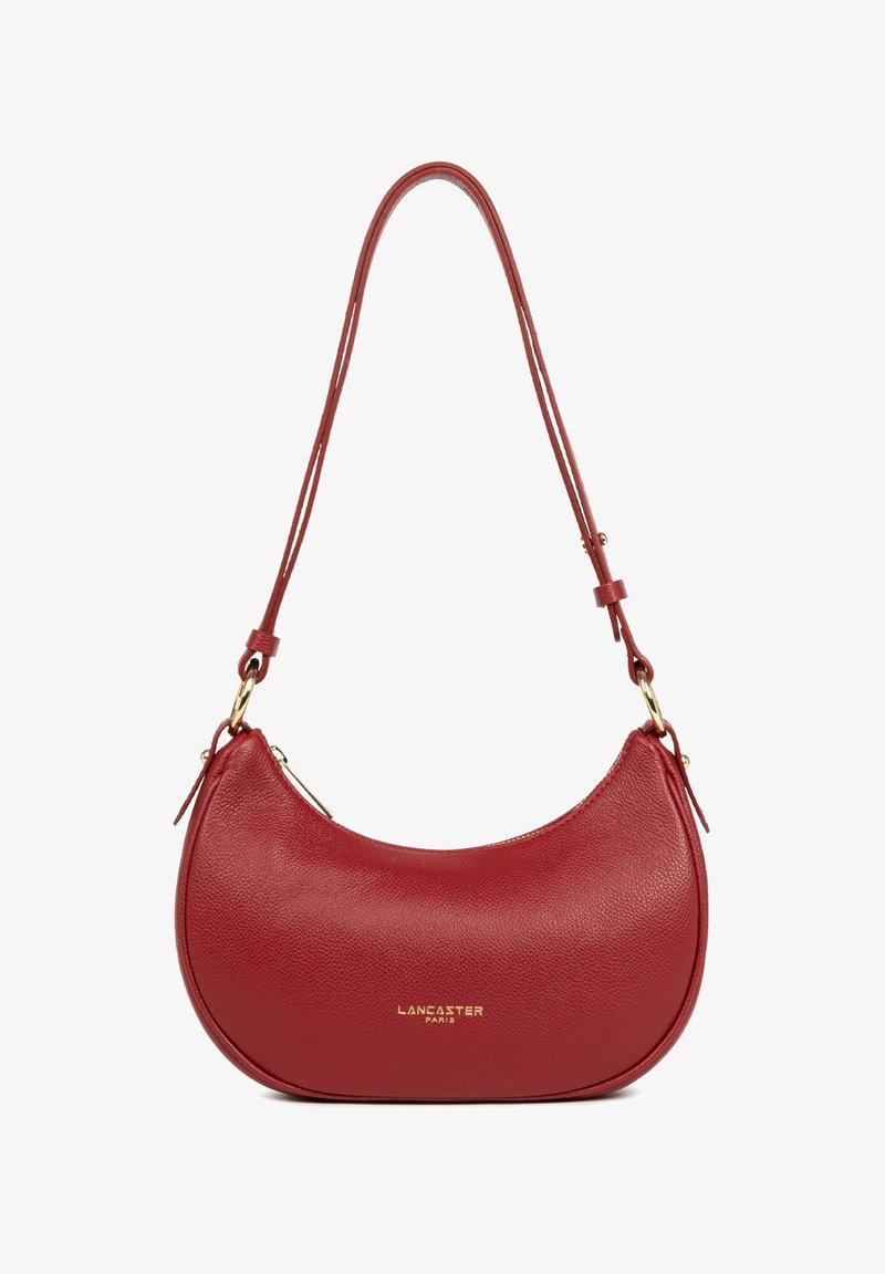 Sac à bandoulière en cuir rouge avec une forme arrondie, affichant une texture lisse, des accessoires en or et une bandoulière ajustable. Logo embossé à l'avant.