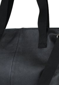 Zwarte leren totebag met een gestructureerde afwerking, voorzien van stevige stoffen handvatten en een naadloos ontwerp. Inclusief metalen accenten.