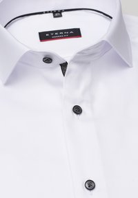 Witte ETERNA moderne fit overhemd met een gestructureerde kraag, voorzien van zwarte plastic knopen en een contrasterende geplaatste detail aan de knoopsluiting.