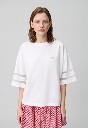 T-shirt blanc surdimensionné à manches courtes avec des détails en bande de maille et une petite étiquette logo. Tissu doux avec une coupe décontractée.