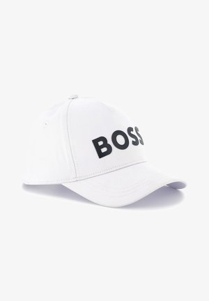 Boné de beisebol branco feito de tecido, apresentando um logotipo preto "BOSS" na frente, aba arqueada e faixa ajustável na parte de trás.
