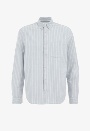 Lys blå skjorte med knapper, hvide lodrette striber, lange ærmer, en enkelt brystlomme og krave. Blød stoftekstur.