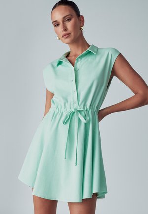 Svetlozelené bezrukávové šaty s gombíkmi vpredu, sťahovaním v páse a voľnou sukňou, vyrobené z ľahkej tkaniny.