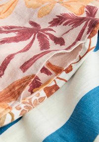Lillemustriga kangas roosade, oranžide ja siniste toonidega. Omaduseks pehme tekstuur ja kihiline disain eristuvate joonte ja värvidega.
