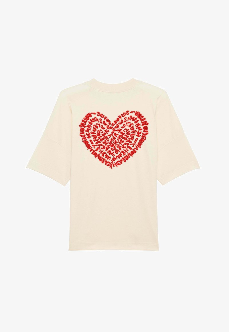 T-shirt en coton couleur crème avec des manches courtes surdimensionnées et un grand graphique en forme de cœur rouge composé de texte, centré au dos.