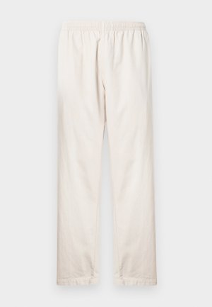 Ανοιχτό μπεζ παντελόνι με ελαστική μέση, ίσια γραμμή και απαλό βαμβακερό ύφασμα. Απλός, χωρίς στολίδια σχεδιασμός.