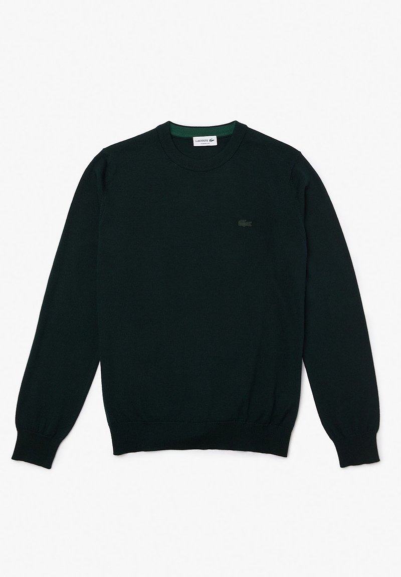 Pull vert foncé en maille douce. Il présente un col rond, des manches longues et un petit logo ton sur ton sur la poitrine gauche.