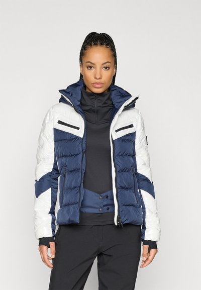 Φουσκωτό μπουφάν με σχέδιο μπλε και λευκού χρώματος, διαθέτει τσέπες με φερμουάρ, ψηλό γιακά και καπιτονέ υφή.