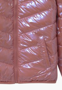 Gewatteerde jas in rozenroze, met een glanzende, doorgestikte textuur, ritssluiting en een zijzak met chevronstikseldetail.