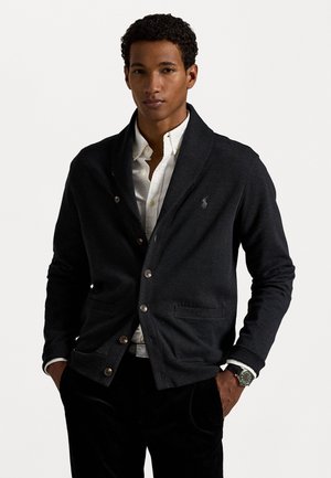 Dark gray knit cardigan with a shawl collar, featuring brown buttons and a left chest polo logo, styled over a white collared shirt.