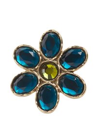 Broche en forme de fleur en or avec six grandes pierres précieuses ovales bleues comme pétales et une pierre précieuse ronde jaune au centre.