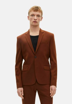Brauner Anzugjacke mit einem Knopfverschluss, zwei vorderen Taschen und schlankem Schnitt. Trägt man über einem schwarzen Hemd. Glatte Stoffoberfläche.