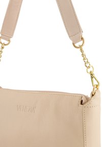 Beige læder håndtaske med prægede "Venezia" logo, guldfarvet hardware, kæde remhæftning, glat tekstur og lynlåslukning.