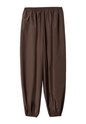 Lockere braune Hose mit elastischem Bund und elastischen Bündchen, dargestellt auf weißem Hintergrund.