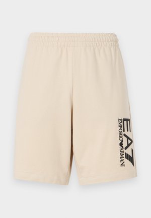 Beige shorts made of soft fabric with an elastic waistband. Features a black logo print on the left side. Simple and functional design.