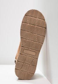 Semelle de chaussure en daim marron avec un motif en zigzag texturé, étiquetée "TOM TAILOR", taille 37, dotée d'un matériau en caoutchouc durable pour l'adhérence et la traction.