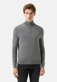 Grauer Reißverschluss-Pullover mit hohem Kragen, langen �Ärmeln und glatter Textur. Verfügt über einen vorderen Reißverschluss und gerippte Bündchen am Saum.