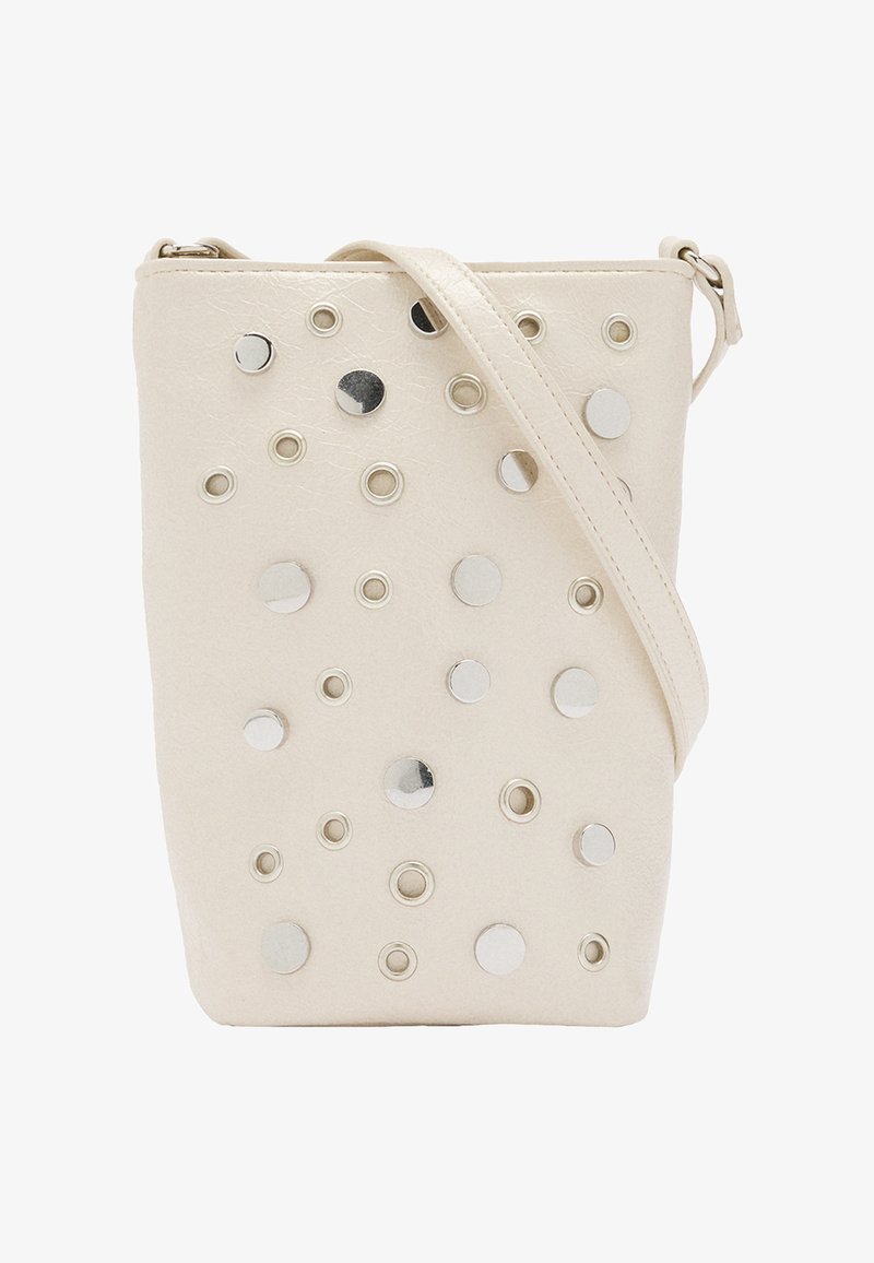 Beżowa torebka crossbody z sztucznej skóry z okrągłymi srebrnymi ćwiekami i oczkami, z cienkim paskiem na ramię i zamkiem błyskawicznym.