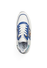 White sneaker with blue accents, circular logo detail, and floral pattern on the side. Features white laces and a textured sole.