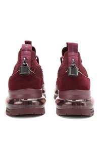 Vínové sportovní boty s texturovaným síťovaným svrškem, zamazanými akcenty a transparentním vzduchovým odpružením. Obsahují poutka a kovové detaily.