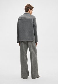 Γκρι σακάκι από μάλλινο μείγμα με φαρδιά γιακά και δομημένη πλάτη, συνδυασμένο με γκρι καρό υφασμάτινο παντελόνι με ψηλή μέση και υφή.