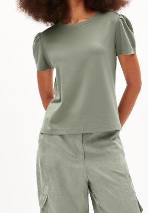 Kurzärmliges T-Shirt mit Rundhalsausschnitt in Olivgrün, aus glattem Stoff gefertigt. Es hat voluminöse Ärmel und einen lockeren Sitz, kombiniert mit passenden Hosen.